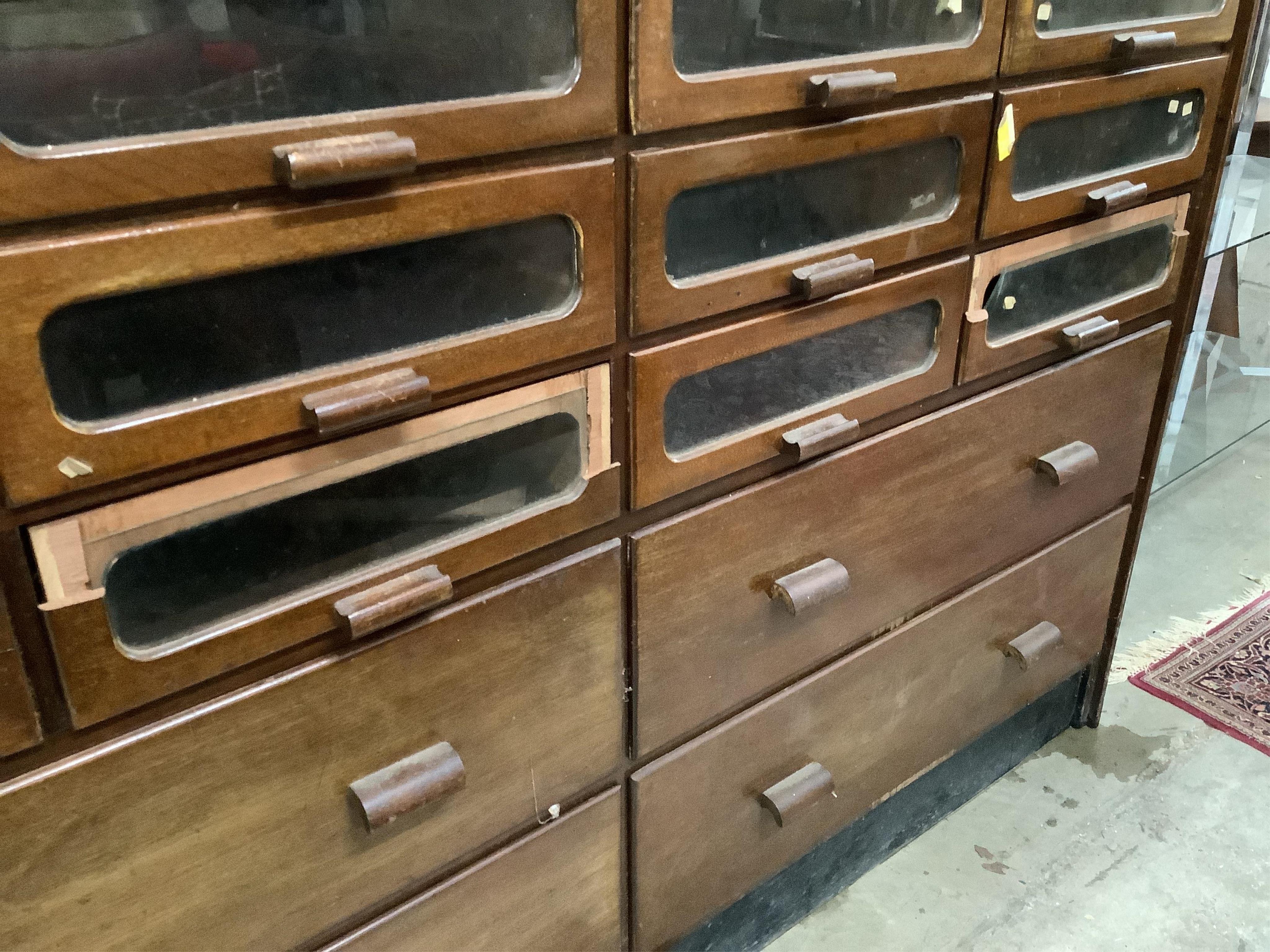 A large mid century mahogany haberdasher's cabinet, width 183cm, depth 50cm, height 199cm. Condition - poor